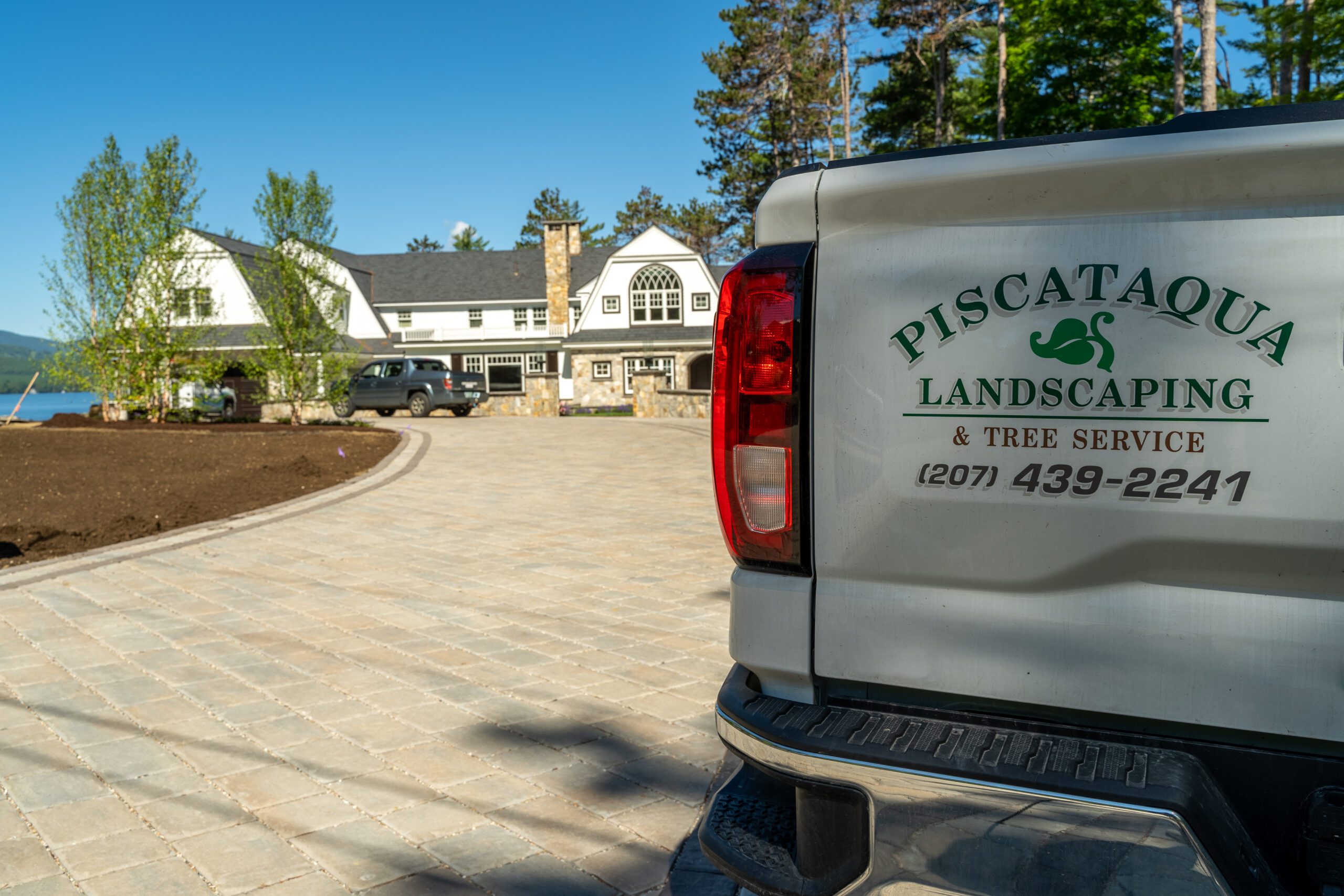 A beautiful house on the Seacoast with a Piscataqua Landscaping Truck in the forefront.